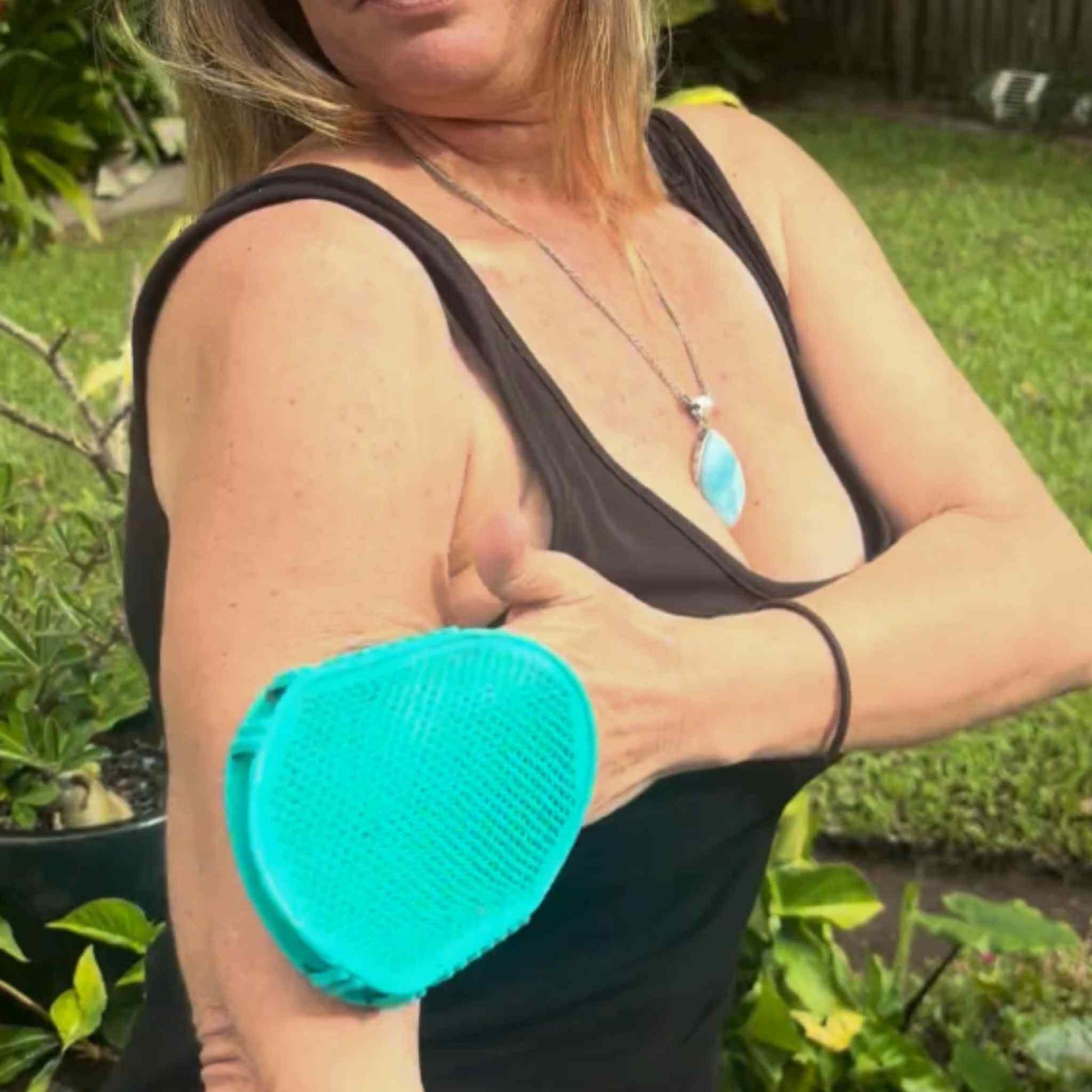 A lady using the Chelsey Jean Dual Action Lymphatic Gloves outside